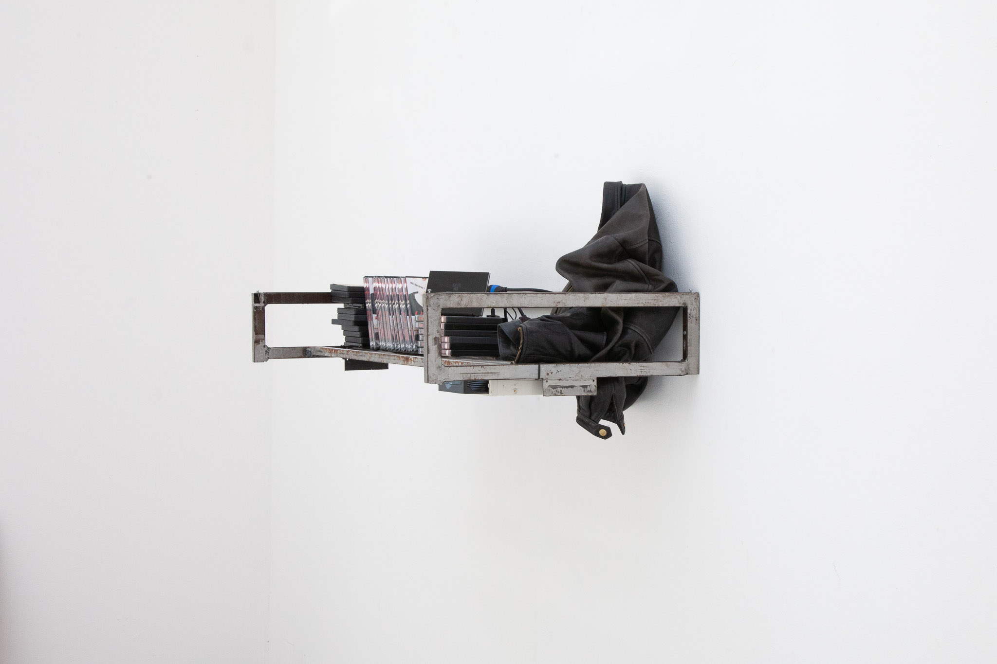 <em>Leather jacket for rainy nights II</em>, 2024. leather jacket, steel, doll house lamp, DVDs, video loop 5'25, screen, desk speakers. Exhibition view: <em>Playlist for an eternal Autumn</em>, Haute Ecole des Arts du Rhin, Strasbourg (FR), 2024. Photo © ALLOK7.FR