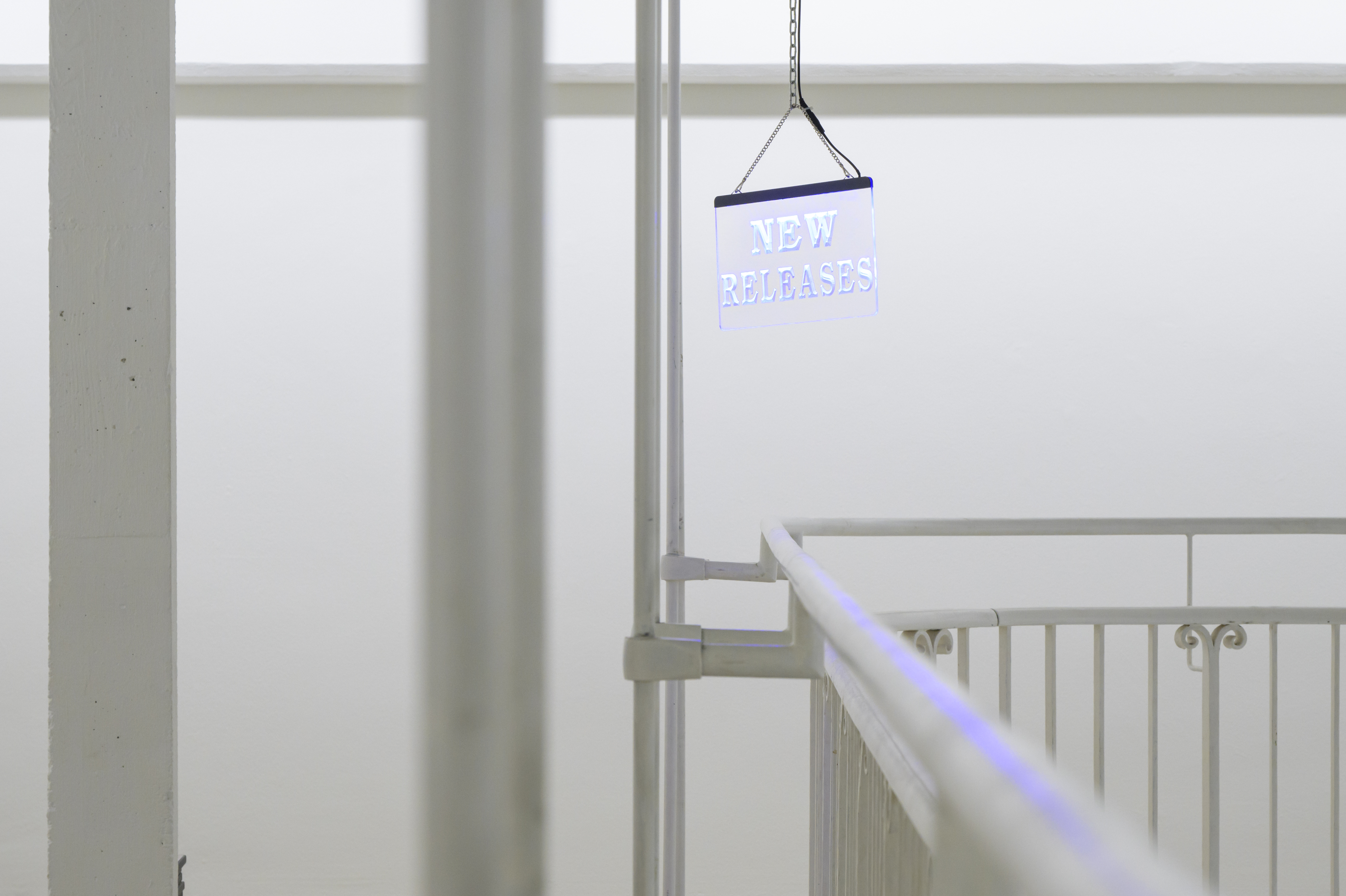 <em>New Release</em>, 2023. led plexiglass panel, chains. 35x42cm. Exhibition view: <em>Will I still perform tomorrow ?</em>, Kunstverein Freiburg, 2023-2024. Part of Regionale 24. Curated by Heinrich Dietz and Marilena Raufeisen. Photo © Marc Doradzillo